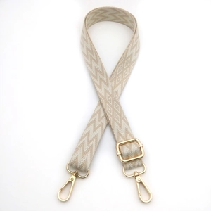 Detail of adjustable woven bag strap featuring gold metal lobster clasps and geometric patterns