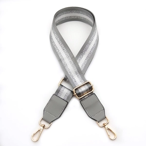 Adjustable grey fabric bag strap with silver stripes and golden metal lobster clasps