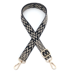Detail of adjustable geometric black and white woven strap with gold metal hooks