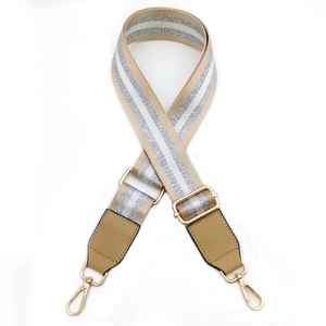 Close-up of adjustable striped fabric strap with leather ends and gold metal buckles
