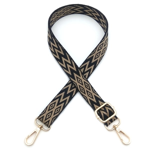 Adjustable woven bag strap with black and yellow geometric patterns and gold metal hooks