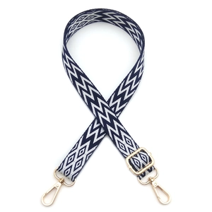 Detail of adjustable woven bag strap with navy and white geometric jacquard pattern