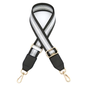 Detail of adjustable black and white striped PU leather strap with gold metal lobster clasp