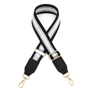Detail view of adjustable black PU leather bag strap with silver glitter stripes and gold buckles