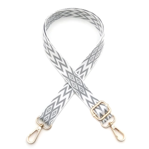 Detail of grey and white geometric woven strap with adjustable gold metal buckle hooks