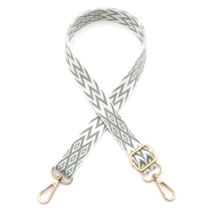 Close-up of bohemian green and white geometric bag strap with gold metal hooks