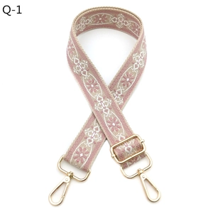 Detail of adjustable bohemian guitar style strap with pink floral jacquard pattern and gold hooks