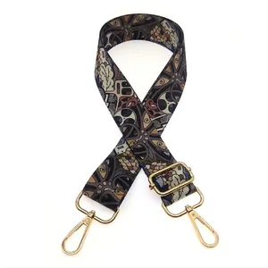 Detailed view of ethnic jacquard bag strap with geometric pattern and gold metal hooks