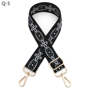 Detailed view of ethnic embroidery bag strap with gold metal hooks and adjustable buckle