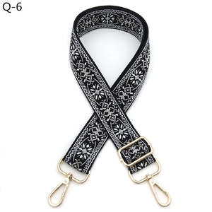 Close-up of ethnic embroidered guitar strap with gold lobster clasps and floral pattern