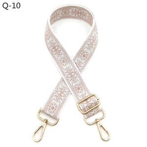 Close-up of ethnic style embroidered floral bag strap with light gold metal hardware
