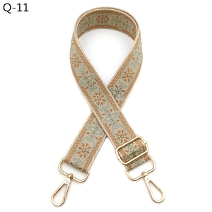 Detailed view of bohemian floral jacquard bag strap with golden metal carabiner clips