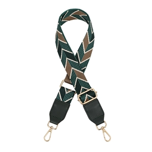 Detail view of adjustable bag strap featuring retro green and brown wavy woven patterns