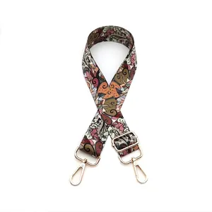 Close-up of ethnic patterned bag strap with golden metal lobster clasps and buckle