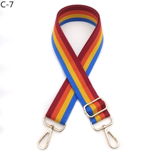 Detail of adjustable rainbow striped wide bag strap with gold metal lobster clasps