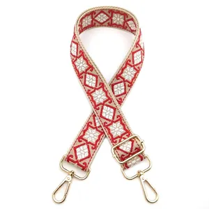 Detail of adjustable geometric diamond pattern bag strap with gold metal hooks