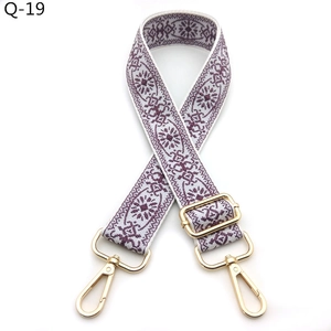 Detail of adjustable purple and white jacquard guitar strap with gold metal hardware
