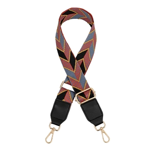 Detail of adjustable woven bag strap with colorful geometric chevron patterns and gold hardware