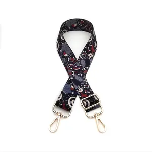 Close-up of wide ethnic style bag strap with vintage patterns and gold metal buckles