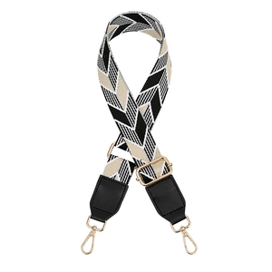 Detail of chevron pattern woven bag strap with golden metal lobster clasps and leather ends