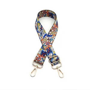 Close-up of adjustable woven bag strap with colorful geometric patterns and gold metal hooks