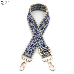 Detail of adjustable woven bag strap with blue ethnic patterns and gold lobster clasps