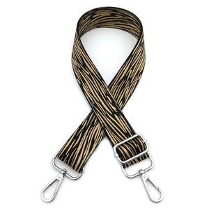 Close-up of adjustable fabric bag strap with black and beige tiger pattern and silver hardware
