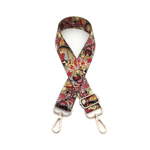 Detail of adjustable wide shoulder strap with colorful ethnic pattern and gold metal hooks