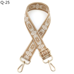 Close-up of bohemian style embroidered bag strap with floral pattern and gold metal clips