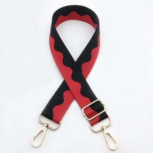 Close-up of red and black wave pattern bag strap with adjustable gold metal buckle