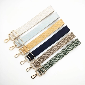 Close-up of adjustable woven shoulder straps with diverse geometric patterns and gold metal hooks