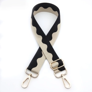 Detail of adjustable black and white wave pattern bag strap with gold metal hooks