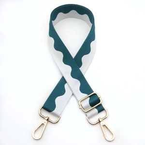 Detail of adjustable blue and white wave pattern bag strap with gold metal buckles