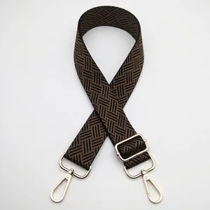 Macro detail of adjustable woven shoulder strap with gold hardware and geometric pattern