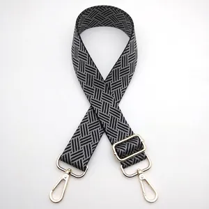 Macro shot of adjustable woven bag strap with geometric texture and gold metal hooks