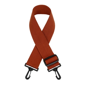 Close-up of brick red woven bag strap with matte black buckle and lobster hooks