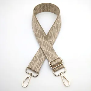 Detail of woven geometric bag strap in beige and brown with gold alloy rotating hooks