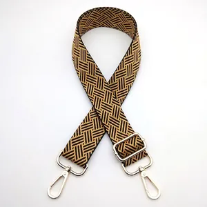 Detail of adjustable woven bag strap with geometric patterns and gold lobster clasps