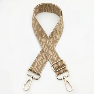 Close-up of woven bag strap in coffee and beige chevron pattern with gold metal clasps