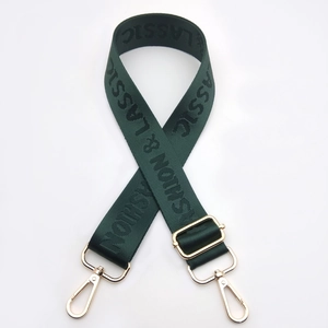 Detail of dark green woven nylon strap with gold metal hooks and fashion lettering