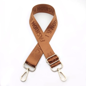 Detail of adjustable nylon strap with gold hardware and fashion letter jacquard weaving