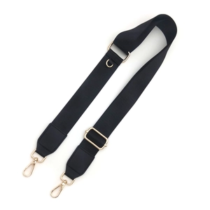 Detail of adjustable black fabric shoulder strap with gold metal swivel hooks and D-ring