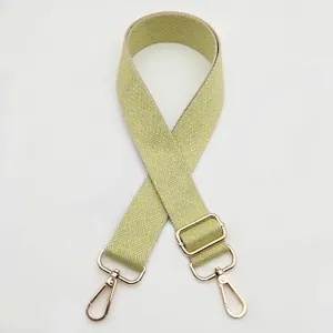 Detail of woven replacement handbag strap in yellow and grey with gold metal hooks