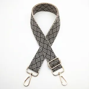 Adjustable woven nylon bag strap with black and white checkerboard pattern and gold clips