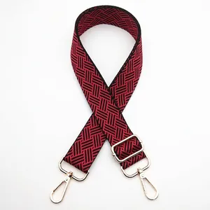 Detail of red and black woven strap with adjustable gold buckle and swivel hooks