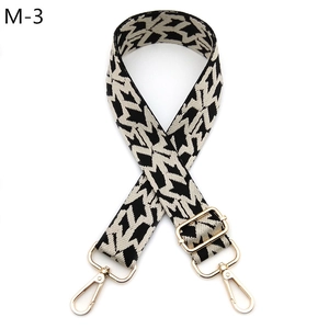 Close-up of adjustable wide shoulder strap with black and white star pattern and gold buckles