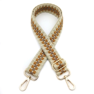 Detail of bohemian geometric woven bag strap with golden metal lobster clasps