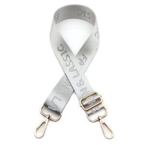 Detail of silver gray nylon guitar strap with gold lobster clasps and fashion lettering