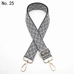 Close-up of black and white woven geometric pattern strap with gold metal hardware