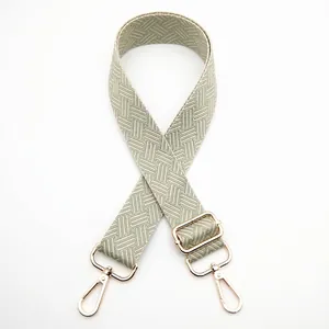 Detail of adjustable woven purse strap with green chevron pattern and gold lobster claws